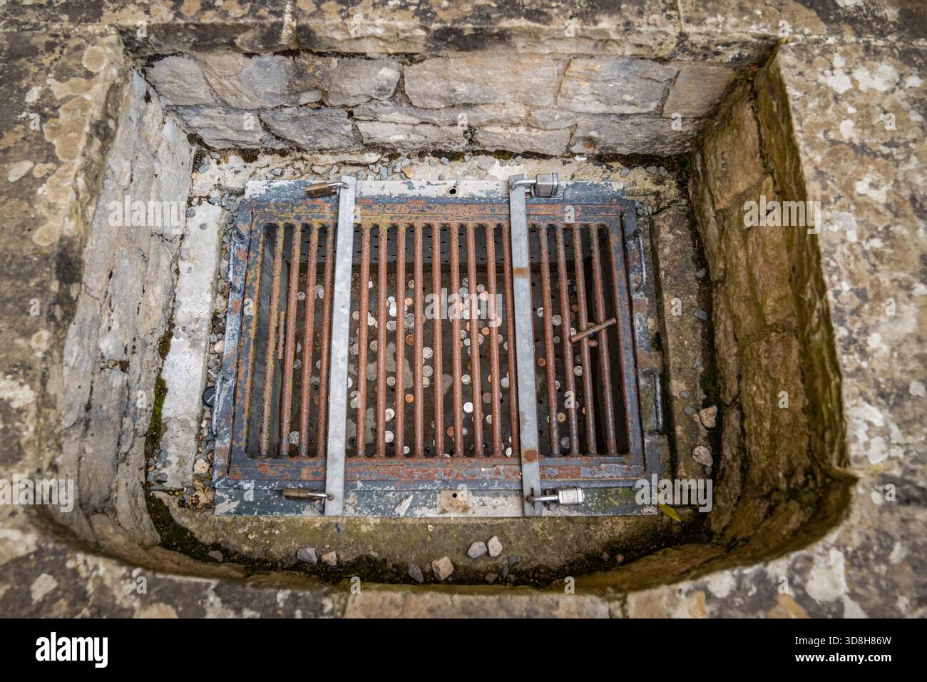 Rosted Wishes erzählt die Geschichte der durch die Zeit erhaltenen Hoffnung. Jede Münze unter dem eisernen Gitter wird zu einem Relikt des vom Alter verwitterten Glaubens. Stockfoto