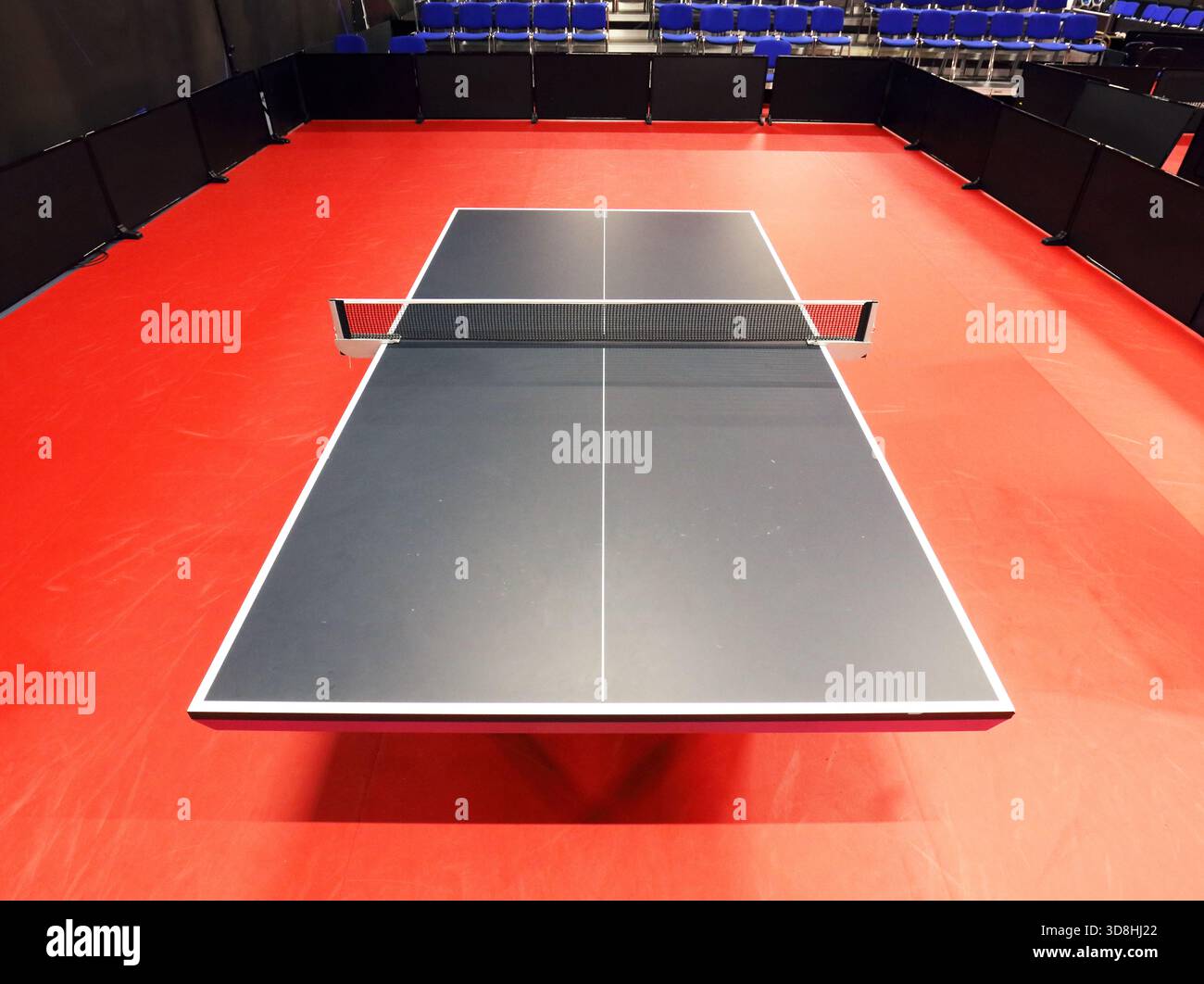 Schwarze Tischtennis- oder Tischtennisplatte befindet sich auf einem roten, orangen Boden des Hallenstadions für Wettbewerbe Turniere Stockfoto