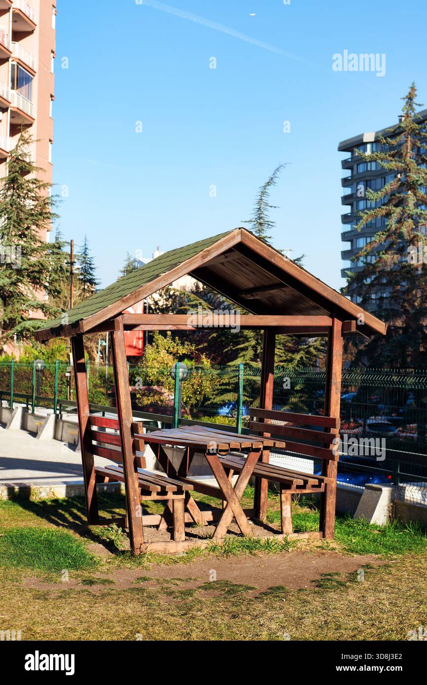 Rustikale hölzerne Pavillon und Picknicktisch bieten einen Ort für Entspannung und Outdoor-Aktivitäten in einem Stadtpark Stockfoto