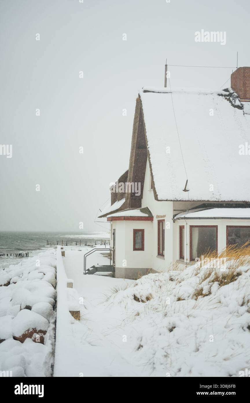 Reetgedecktes, schneebedecktes Strandhaus, Graswarder, Heiligenhafen Stockfoto