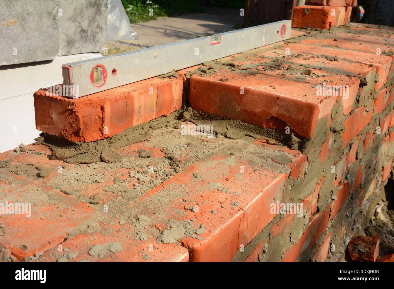 Mauerwandbauprozess mit Nivellierwerkzeug Stockfoto