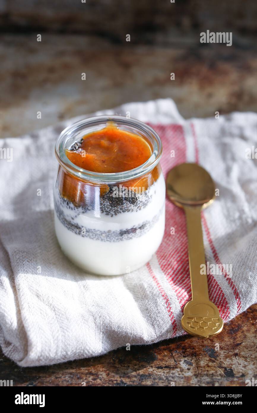 Griechischer Joghurt mit Chiasamen und Pflaumenmarmelade, serviert in einem klaren Glas, ein gesunder und köstlicher Snack Stockfoto