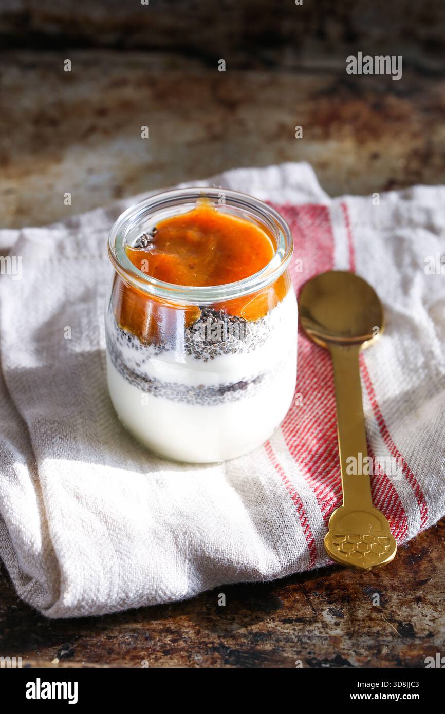 Griechischer Joghurt mit Chiasamen und Pflaumenmarmelade, serviert in einem klaren Glas, ein gesunder und köstlicher Snack Stockfoto