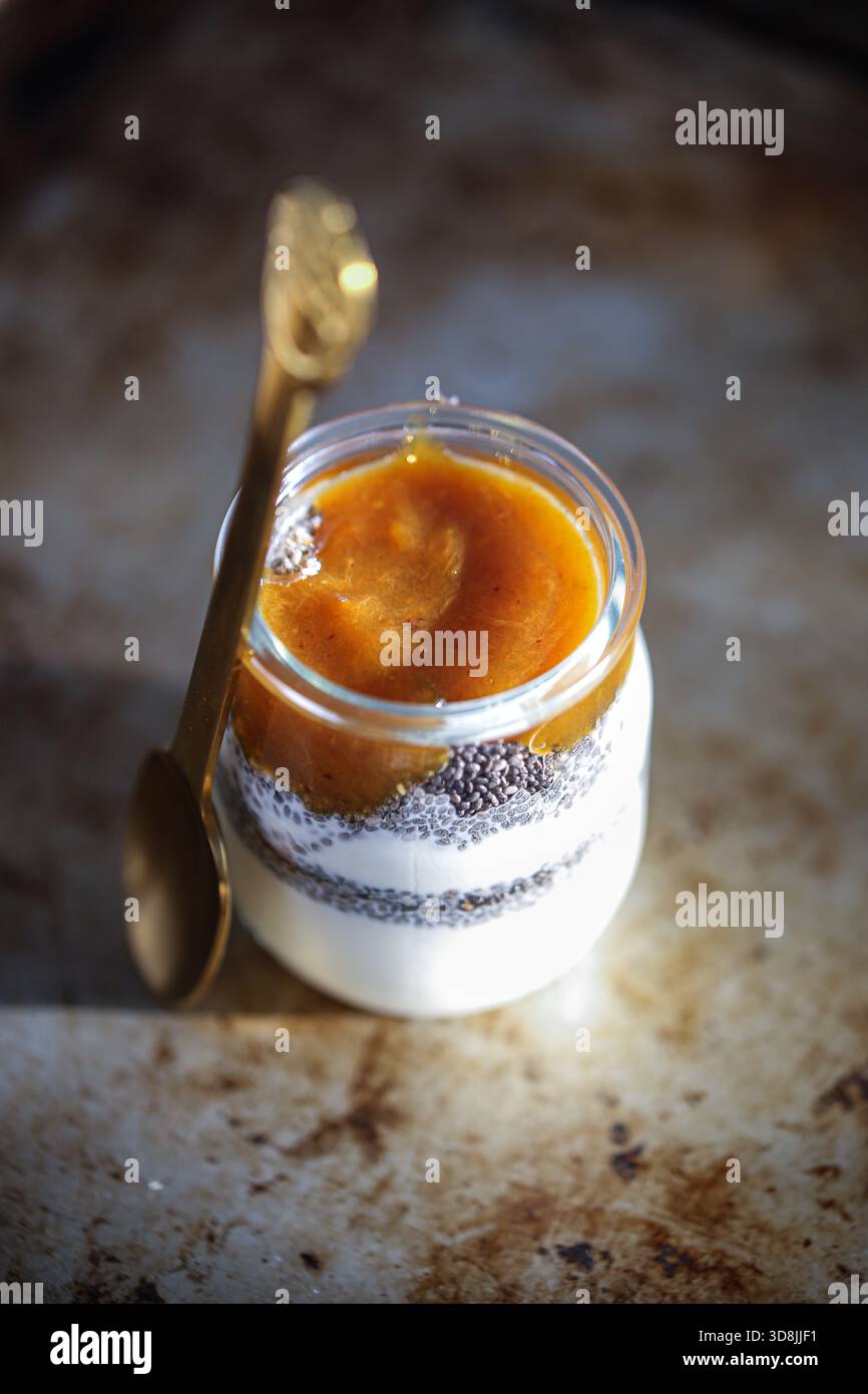 Griechischer Joghurt mit Chiasamen und Pflaumenmarmelade, serviert in einem klaren Glas, ein gesunder und köstlicher Snack Stockfoto