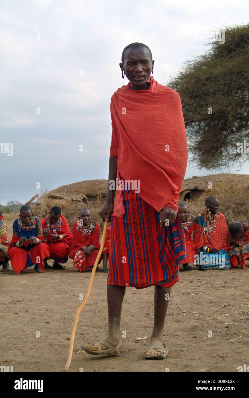 Masai Mara, Kenia - 23. August 2010: Einheimischer Mann und Gruppe nicht identifizierter afrikanischer Frauen aus dem Masai-Stamm in mehrfarbigen Baumwollkleidern und perlenbesetzten Juwelen Stockfoto