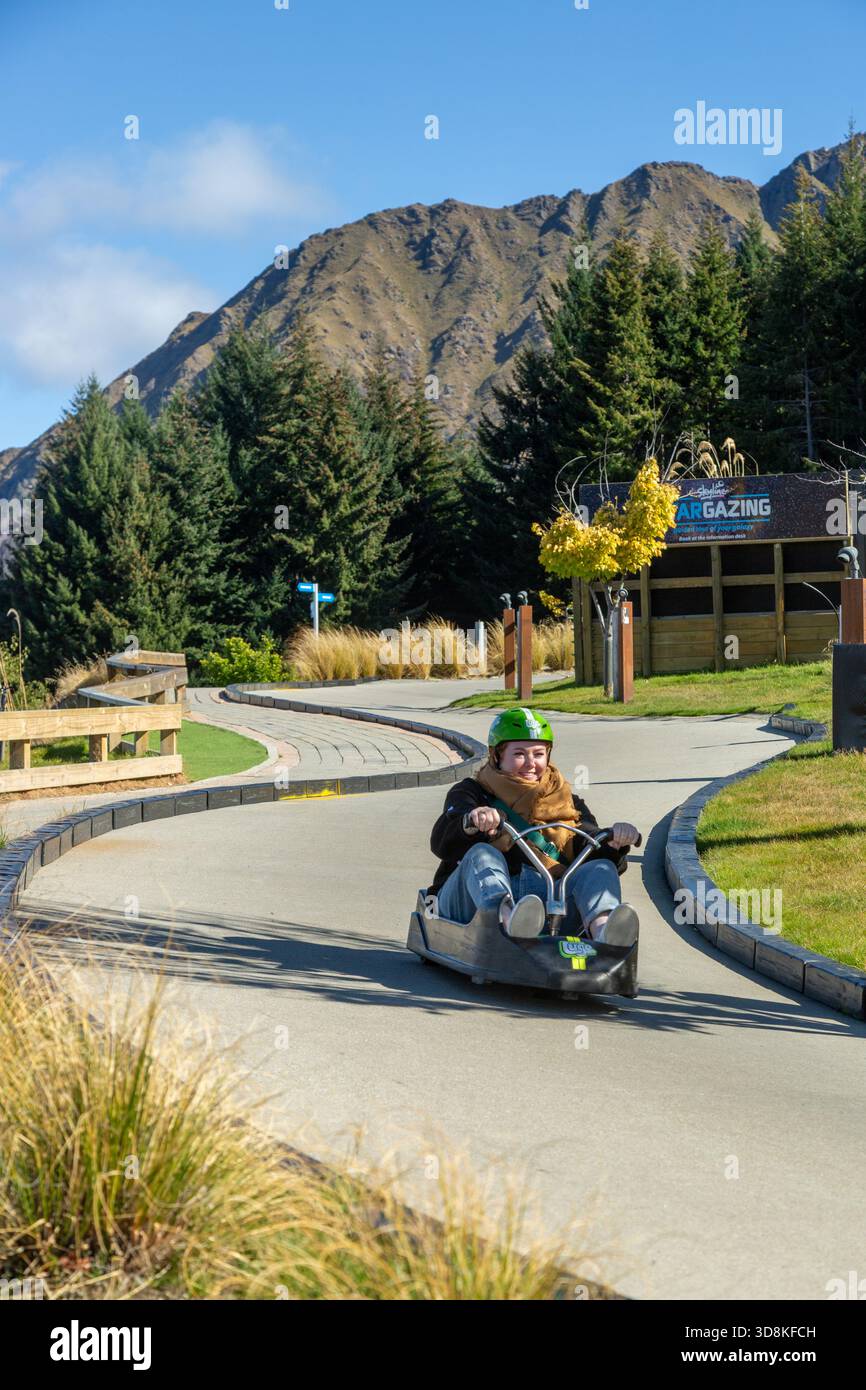 Eine Person, die eine aufregende Fahrt auf der Skyline-Rennrodel in Queenstown, Otago, Neuseeland genießt Stockfoto