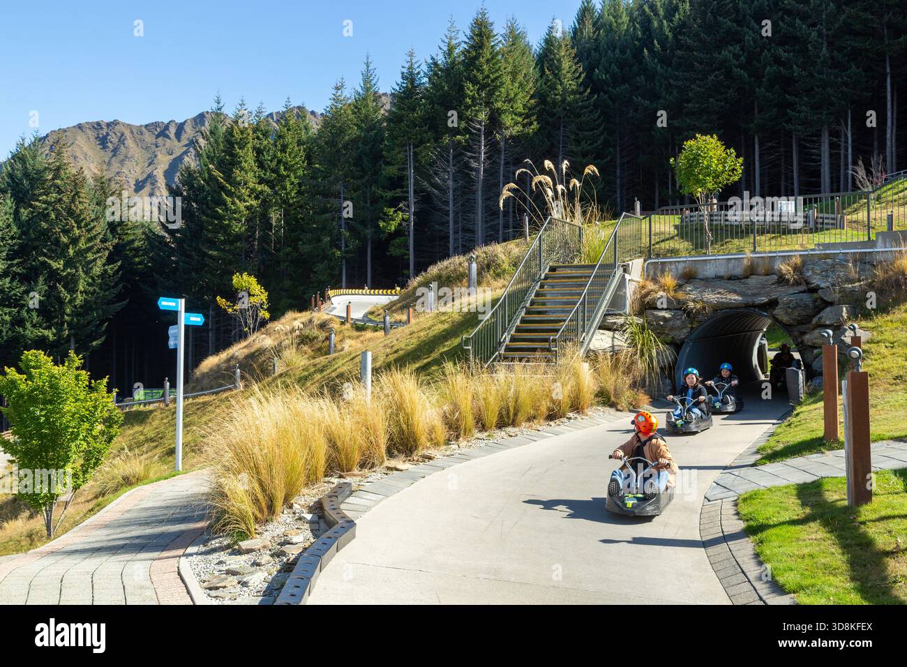 Menschen, die eine aufregende Fahrt mit dem Skyline-Rennrodel in Queenstown, Otago, Neuseeland, genießen Stockfoto