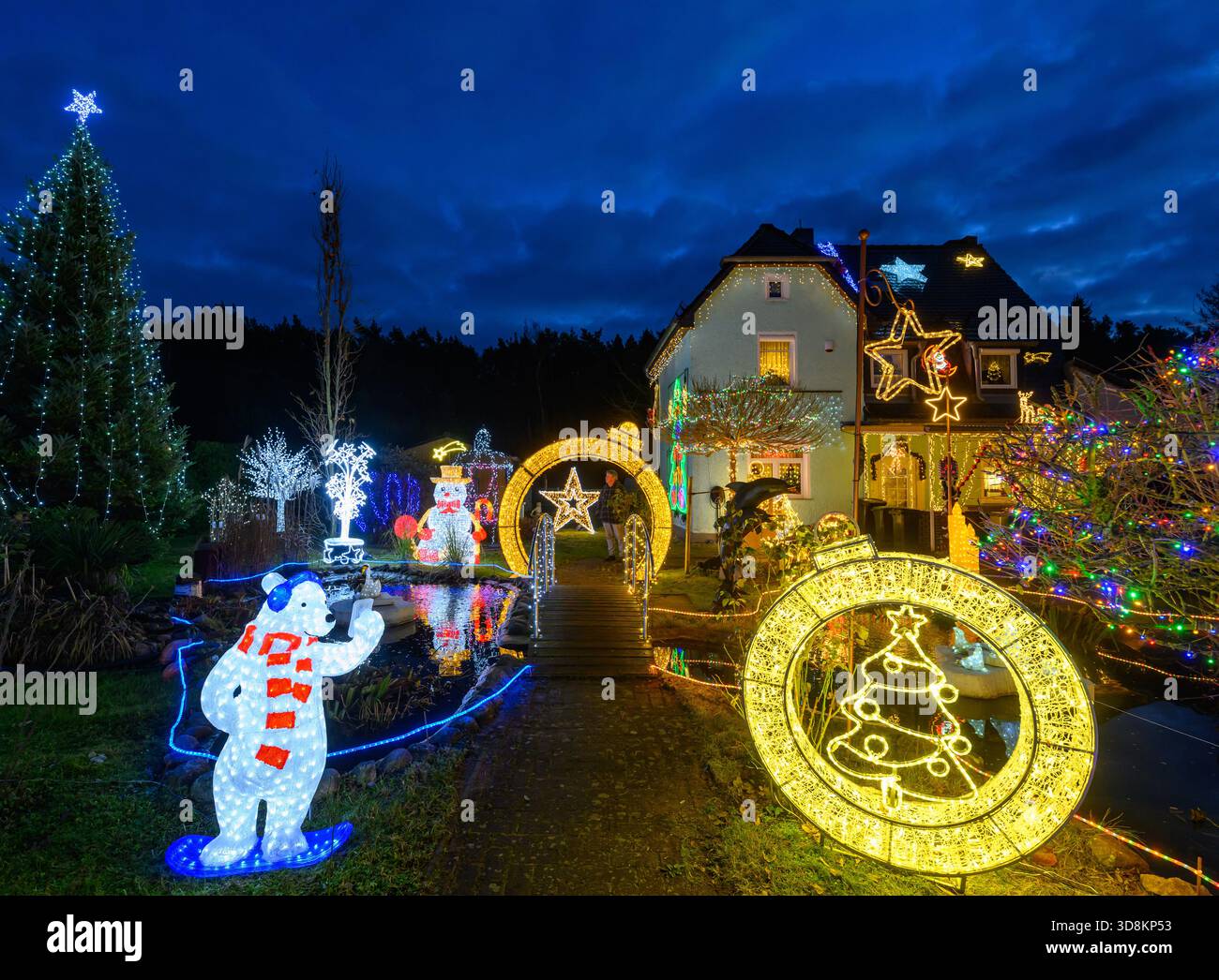 01. Dezember 2025, Brandenburg, Berkenbrück: Jeden Abend verwandelt sich das Anwesen der Familie Muschner in Ostbrandenburgs in ein glitzerndes Winterwunderland. Mehr als 20 Zeitgeber beleuchten die Garten- und Hausfassade im Takt und tauchen das Anwesen in ein Lichtmeer. Die Sammlung wächst seit über zwei Jahrzehnten stetig: Mehr als 100 Figuren bevölkern das Gelände – glitzernde Schneemänner, strahlende Weihnachtsmänner, Rentiere und andere Tierfiguren. Zusammen bilden sie ein leuchtendes Ensemble, das die Besucher von weitem in festliche Stimmung versetzt und den Garten zu einem beliebten Reiseziel macht Stockfoto