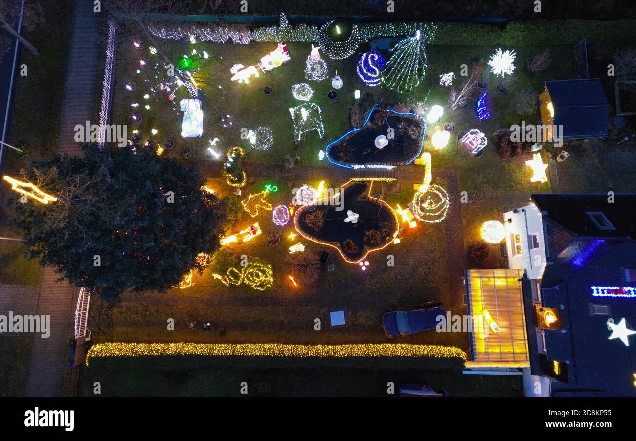01. Dezember 2025, Brandenburg, Berkenbrück: Jeden Abend verwandelt sich das Anwesen der Familie Muschner in Ostbrandenburgs in ein glitzerndes Winterwunderland (Luftaufnahme mit Drohne). Mehr als 20 Zeitgeber beleuchten die Garten- und Hausfassade im Takt und tauchen das Anwesen in ein Lichtmeer. Die Sammlung wächst seit über zwei Jahrzehnten stetig: Mehr als 100 Figuren bevölkern das Gelände – glitzernde Schneemänner, strahlende Weihnachtsmänner, Rentiere und andere Tierfiguren. Zusammen bilden sie ein leuchtendes Ensemble, das die Besucher von weitem in festliche Stimmung versetzt und den Garten zu einem beliebten Ort macht Stockfoto