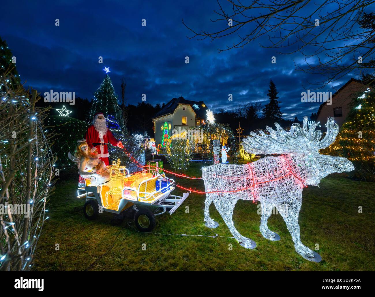 01. Dezember 2025, Brandenburg, Berkenbrück: Jeden Abend verwandelt sich das Anwesen der Familie Muschner in Ostbrandenburgs in ein glitzerndes Winterwunderland. Mehr als 20 Zeitgeber beleuchten die Garten- und Hausfassade im Takt und tauchen das Anwesen in ein Lichtmeer. Die Sammlung wächst seit über zwei Jahrzehnten stetig: Mehr als 100 Figuren bevölkern das Gelände – glitzernde Schneemänner, strahlende Weihnachtsmänner, Rentiere und andere Tierfiguren. Zusammen bilden sie ein leuchtendes Ensemble, das die Besucher aus der Ferne in festliche Stimmung versetzt und den Garten zu einem beliebten Ausflugsziel während der Adv. Macht Stockfoto