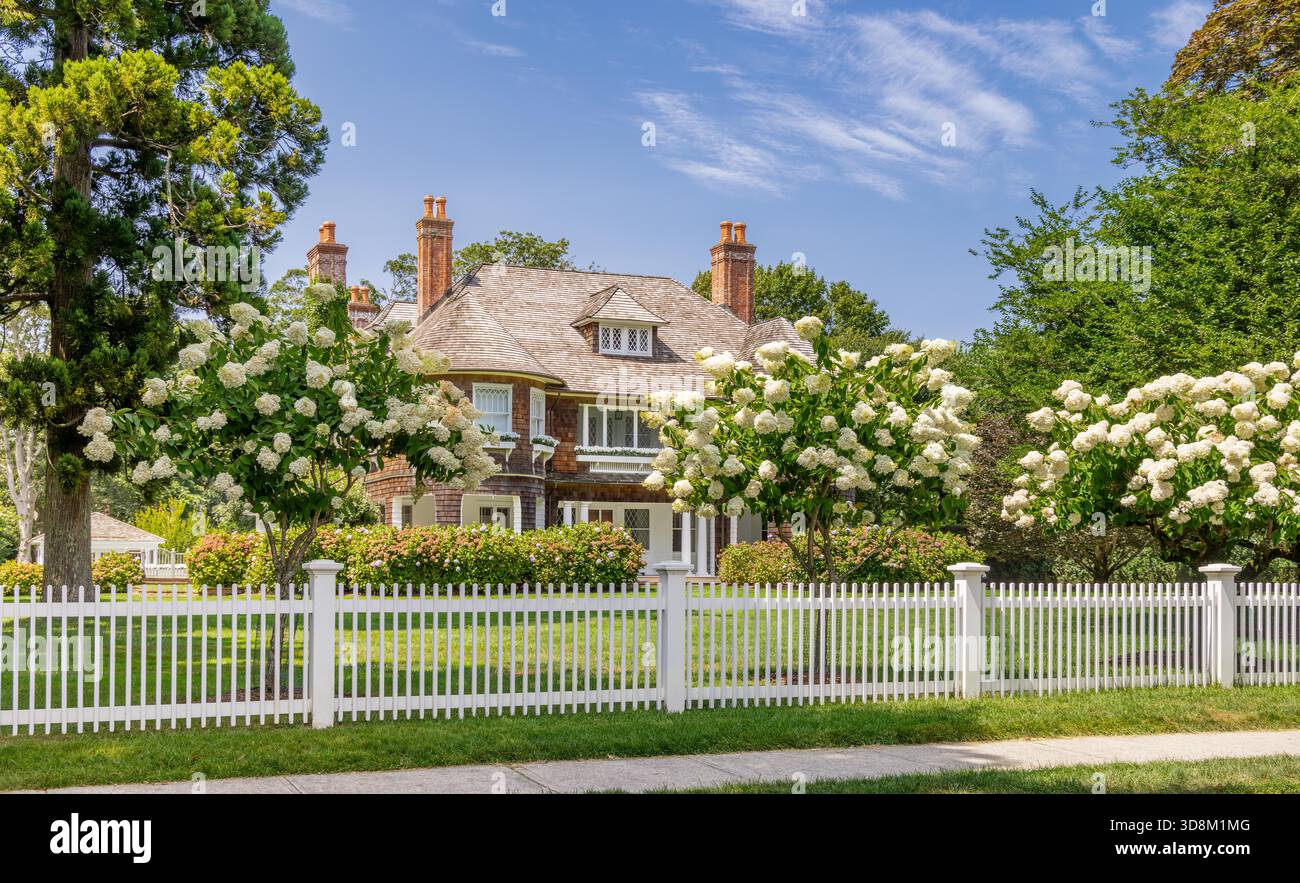 Großes East hampton Haus in einer Sommerlandschaft mit einem weißen Pfahlzaun Stockfoto