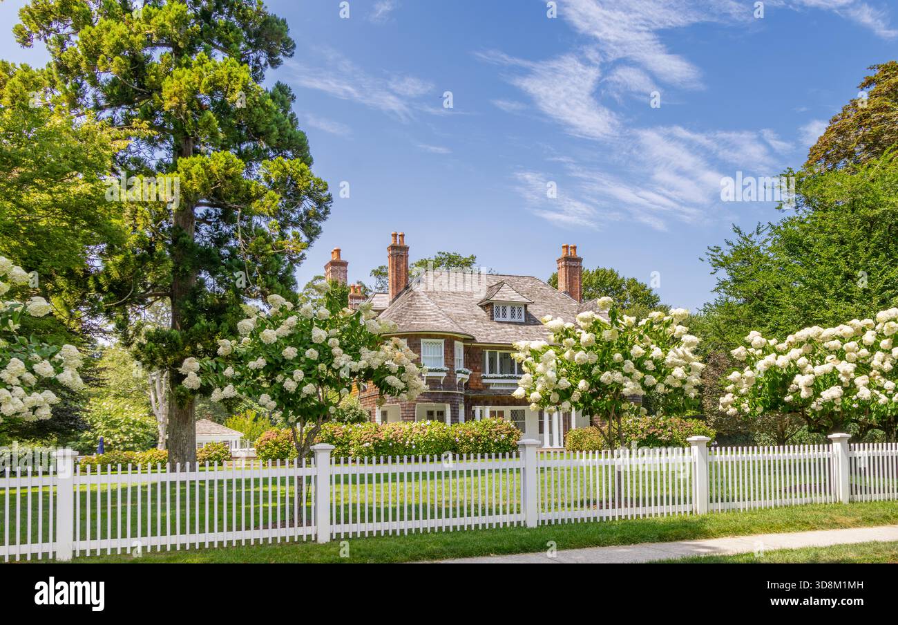Großes East hampton Haus in einer Sommerlandschaft mit einem weißen Pfahlzaun Stockfoto