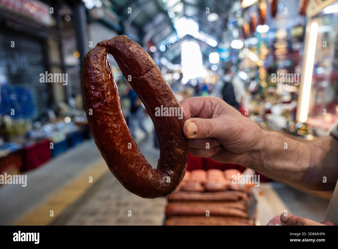 Thessaloniki, Griechenland, 17. September 2025. Aktive Fleischstände auf dem Kapani Market mit Fleischern, die frische Fleischstücke schneiden, präsentieren und an Käufer verkaufen Stockfoto