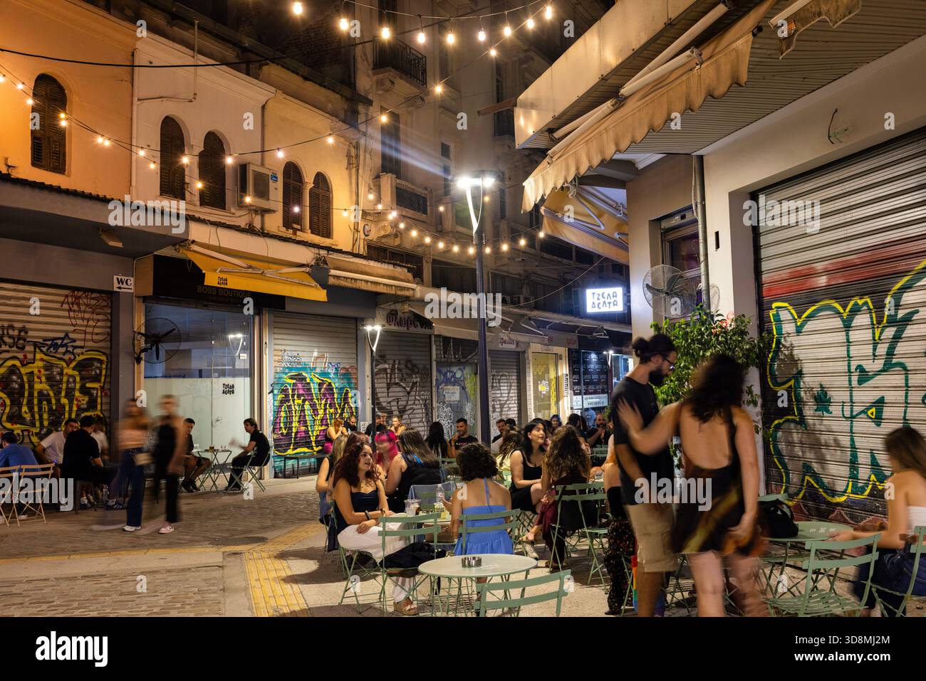 Thessaloniki, Griechenland, 17. September 2025. Der Kapani Market verwandelt sich in ein lebhaftes Lokal mit Tischen, Speisen und Menschen unter festlichen Lichtern. Stockfoto