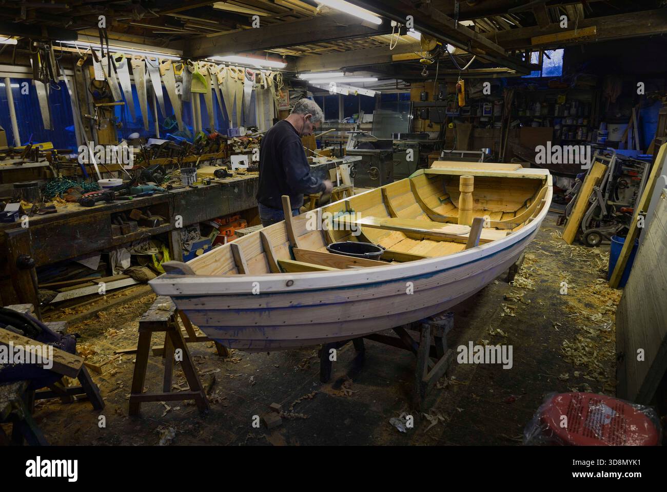 Ian Simpson, der letzte Baumeister traditioneller Ruderboote auf dem Fluss Tweed, arbeitete in seiner Werkstatt in Norham Stockfoto
