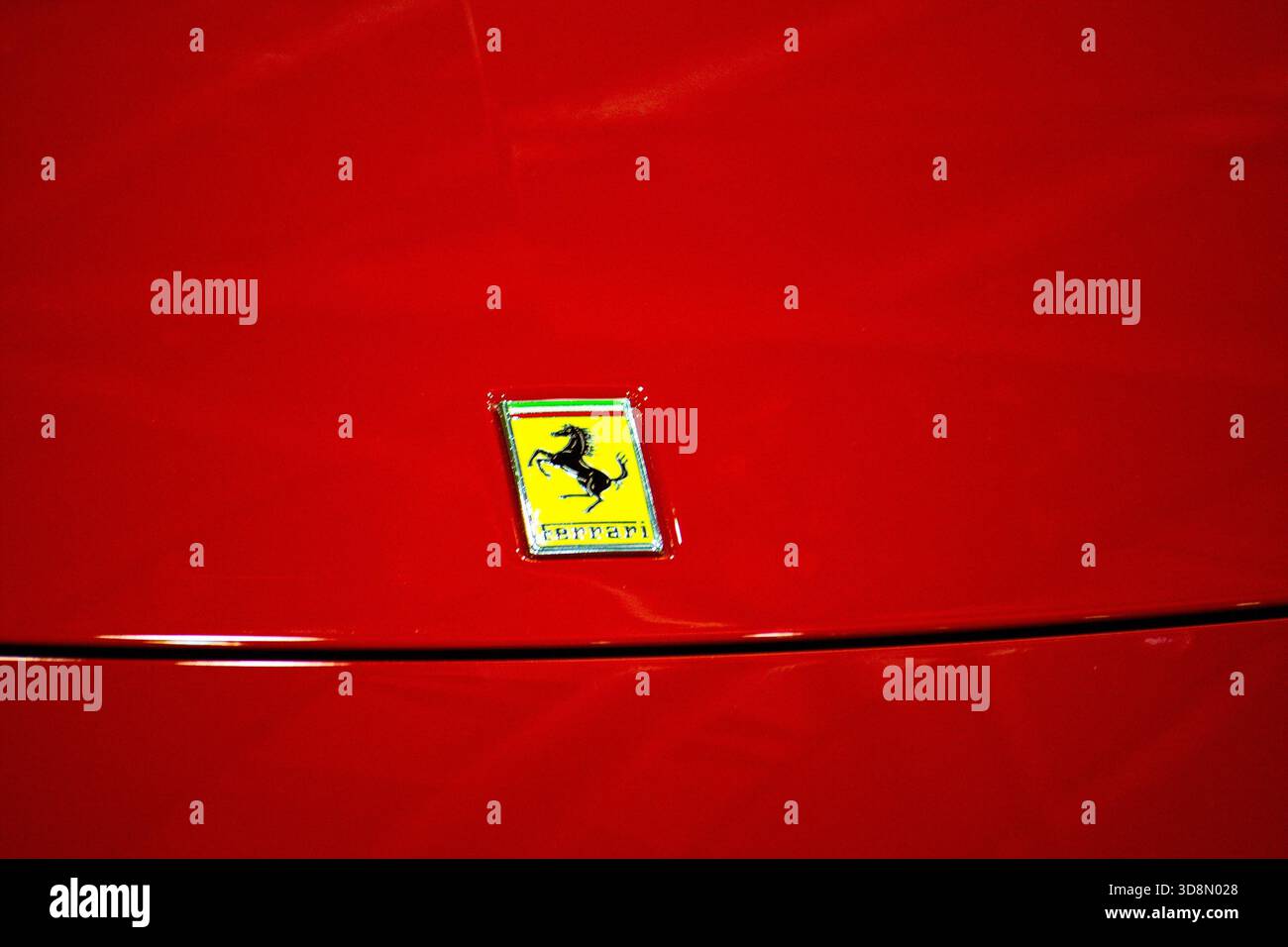 Nahaufnahme eines leuchtenden roten Ferrari-Emblems mit luxuriösem Automobillogo und elegantem Design. Stockfoto