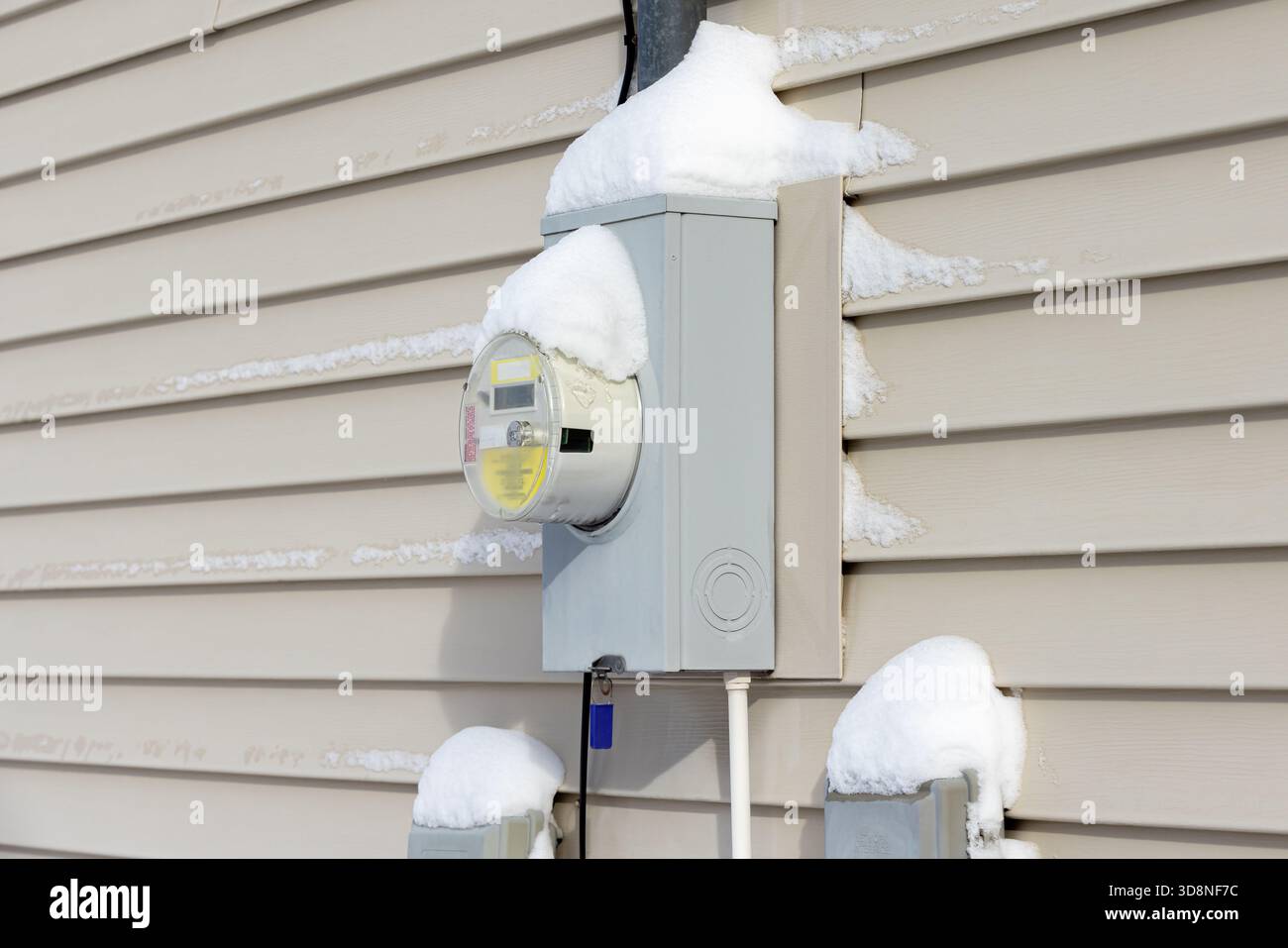 Elektromessgerät im Winter mit Schnee bedeckt. Konzept der Energieeinsparung, der Stromkosten für Haushalte und der Versorgungssicherheit. Stockfoto