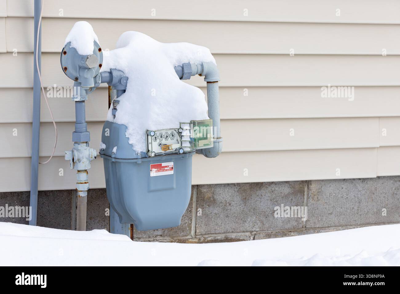 Erdgaszähler im Winter mit Schnee bedeckt. Konzept der Energieeinsparung, der Heizkosten für Wohngebäude und der Versorgungssicherheit. Stockfoto