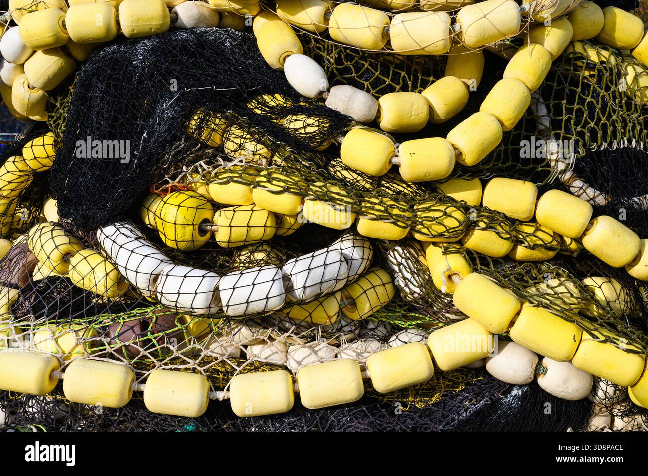 Gewerbliches industrielles Fischernetz in fließender Form mit gelben Schwimmern in Nahaufnahme gelagert Stockfoto