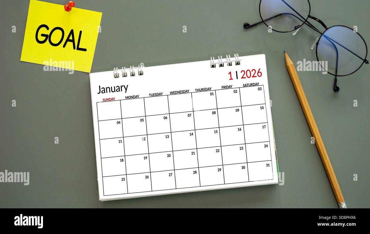 Neujahrskalender 2026, Januar mit WORTZIEL auf Post-it Papiernadel auf grünem Hintergrund, Bleistift und Brille daneben. Symbolisieren Sie Neujahrsziele Stockfoto