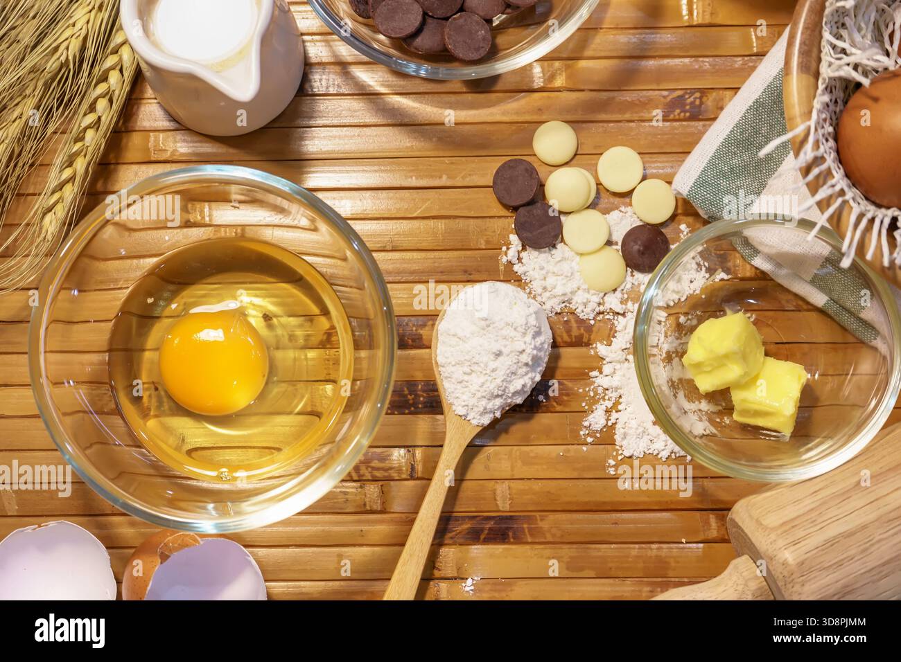 Set mit Backzutaten mit Eigelb, Mehl, Butter und Schokoladenchips auf dem Tisch. Stockfoto
