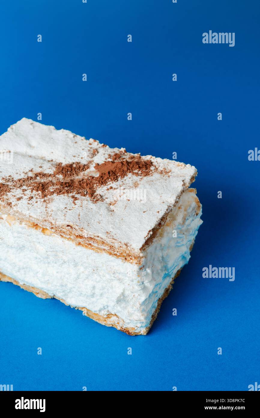 Ein genauer Blick auf einen spanischen Milhojas de merengue unterstreicht den Kontrast zwischen den knusprigen Blätterteigschichten und den dicken weißen Meringue, die alle mit einem Topping belegt sind Stockfoto