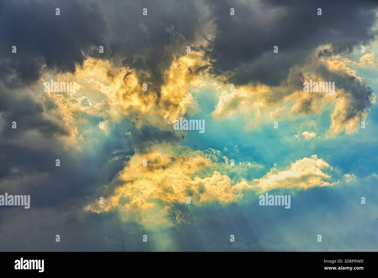 Sonnenlicht, das durch dunkle Sturmwolken filtert, erzeugt spektakuläre Lichtstrahlen am Himmel, die das natürliche Wetterphänomen beleuchten. Abruzzen Stockfoto