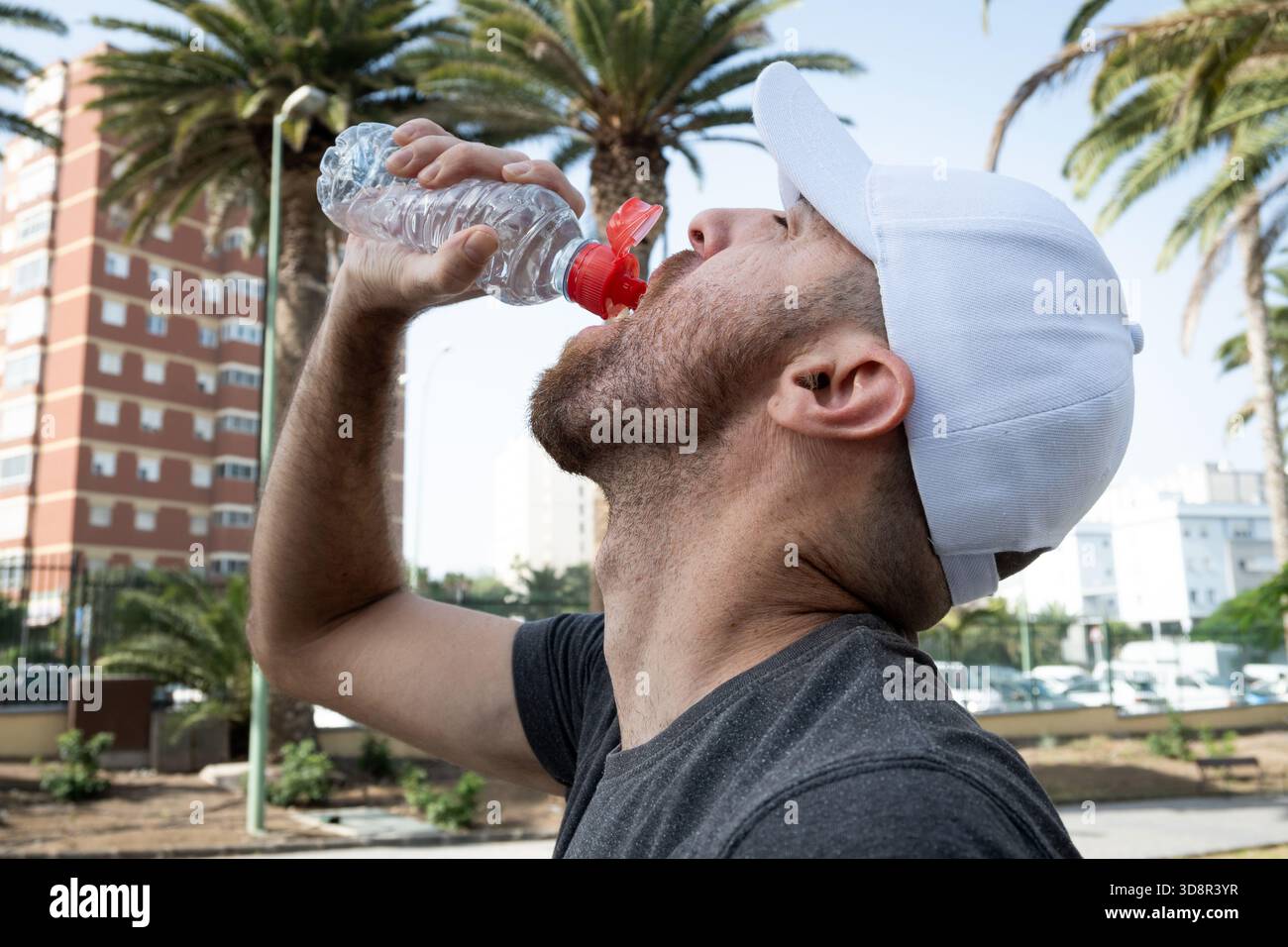 Junger Mann trinkt Wasser nach einem Outdoor-Workout in der Stadt. Stockfoto