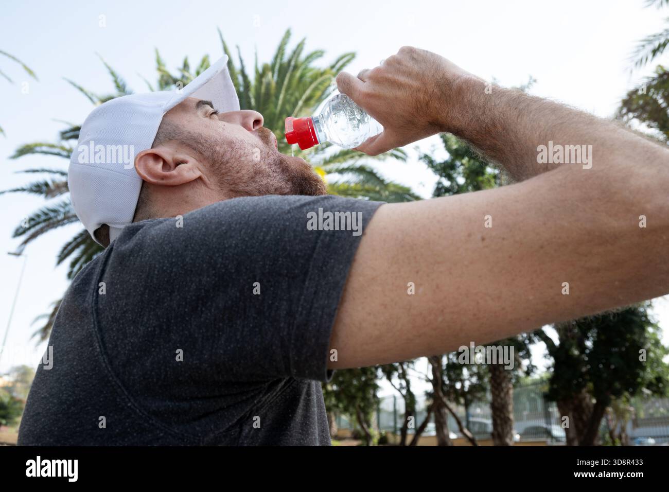 Junger Mann trinkt Wasser nach einem Outdoor-Workout in der Stadt. Stockfoto