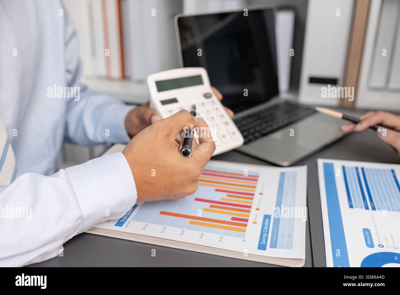 Geschäftskollegen prüfen gemeinsam Budgetdiagramme in einem modernen Büro und konzentrieren sich dabei auf finanzielle Erkenntnisse, Leistungskennzahlen und strategische Planung Stockfoto