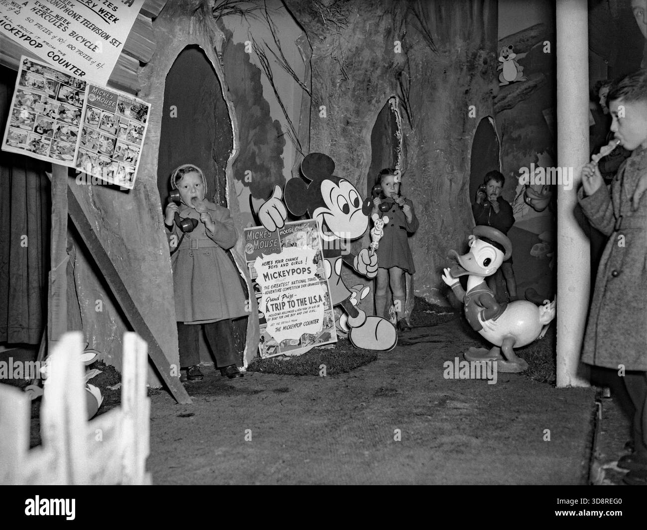 Eine sehr frühe Version von „Disneyland“, die im Jahr 1956 im Ausstellungszentrum Bingley Hall in Birmingham, West Midlands, England, Vereinigtes Königreich entstand. Der „Pop-up“-Bereich diente in erster Linie der Werbung für „Disneypops“, Disneys eigene Marke von Eislutschen oder Eislutschen. Ebenfalls gefördert wurde der britische Comic „Mickey Mouse Weekly“. Zu den Preisen zählten eine Reise nach Hollywood, ein Hercules-Fahrrad und ein Fernseher – ein Vintage-Foto aus den 1950er Jahren. Stockfoto