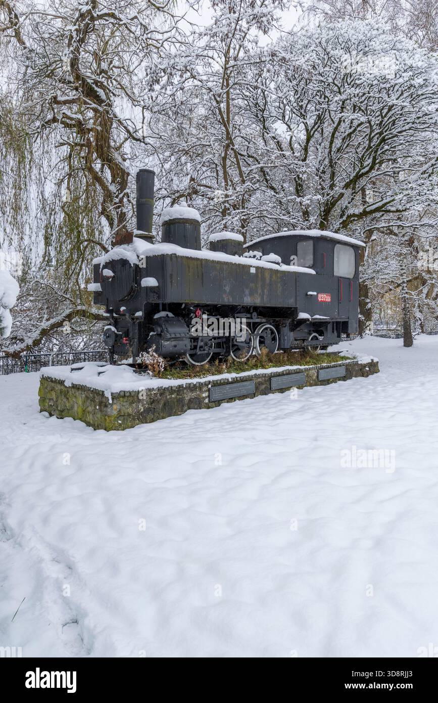 Eine alte Dampflokomotive, die im Winter in einem Bahnhof mit weißem Schnee bedeckt ist Stockfoto