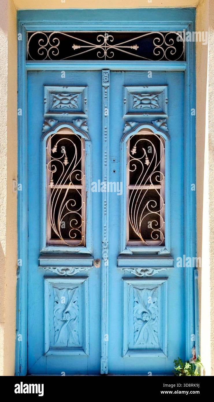 Zweiflügelige Holztür im Vintage-Stil in Hellblau mit raffinierten Metallic-Designs Stockfoto