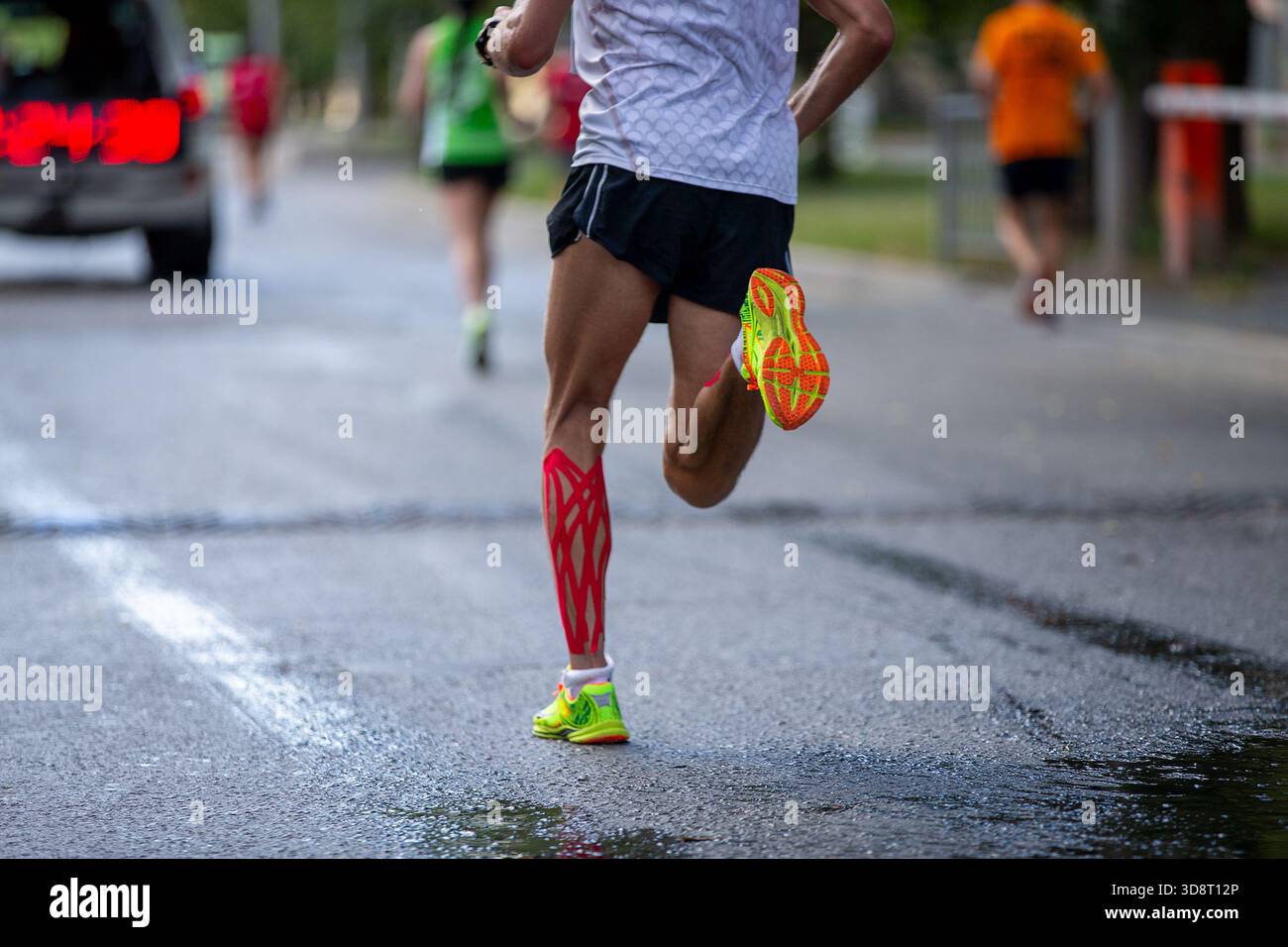 Leader Marathonrennen, das nach dem Auto läuft, mit Zeitanzeige Stockfoto