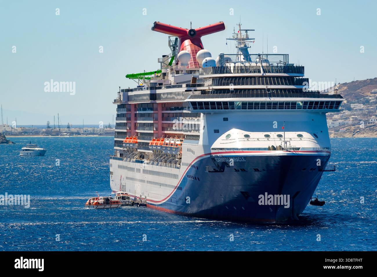 Mykonos, Kykladen, Griechenland - das Kreuzfahrtschiff KARNEVALSWUNDER liegt in der Bucht vor Mykonos-Stadt. Die Tellerboote bringen Touristen an Land. Stockfoto