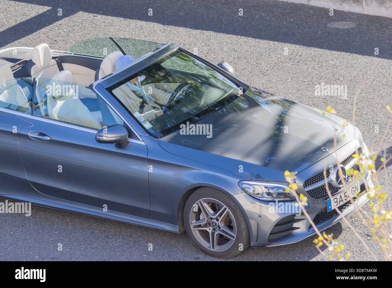 Frau, die ein luxuriöses mercedes-benz-Cabrio auf einer Straße fährt und einen sonnigen Tag genießt Stockfoto