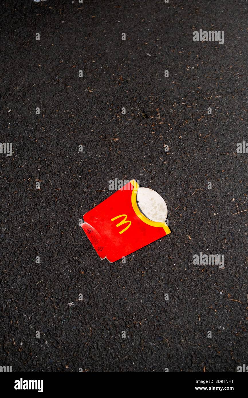 Der McDonalds-Pommes-Container wurde am 2. August 2023 auf der Straße in Toulouse in Occitanie in Frankreich entsorgt. Der Einstreu ist auf dem Asphalt sichtbar, hoch Stockfoto