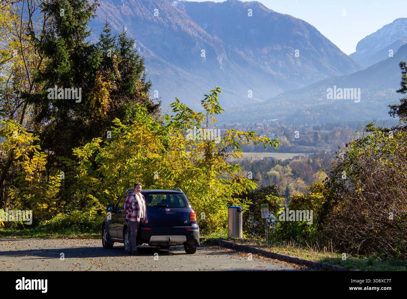 Eine stehende Frau hat ihr Auto auf einem Parkplatz geparkt Stockfoto