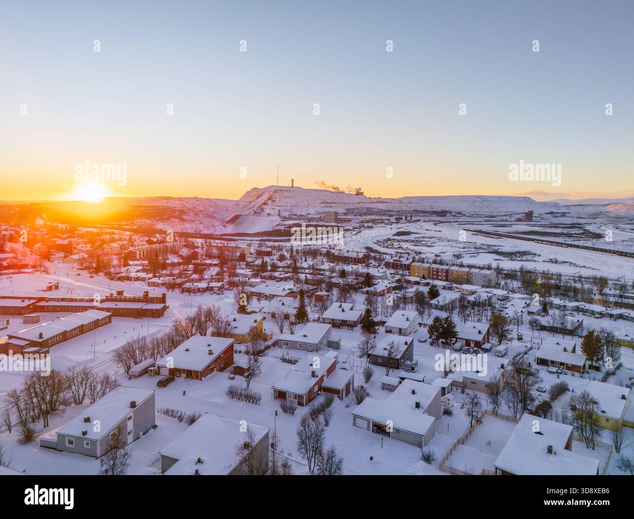 Kiruna und das Eisenerzbergwerk in Schweden, am Mittag während des arktischen Winters, Schnee, bunte Häuser, Sonne knapp über dem Horizont Stockfoto