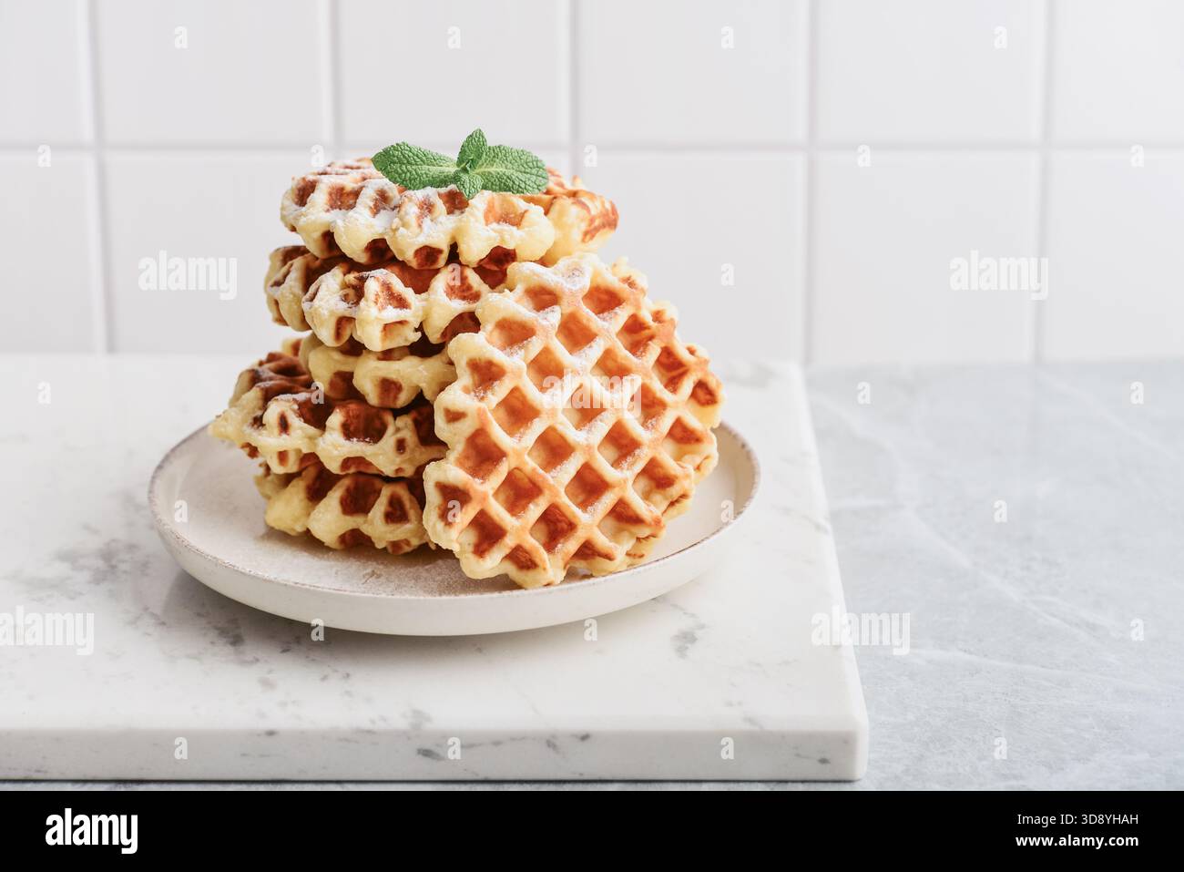 Stapel frischer hausgemachter Waffeln auf einem Teller auf hellem Hintergrund Stockfoto