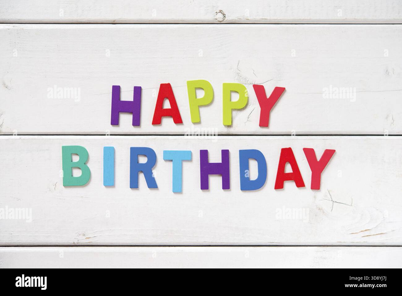 Die bunten Worte HAPPY BIRTHDAY mit Holzbuchstaben auf weißem Brett Stockfoto