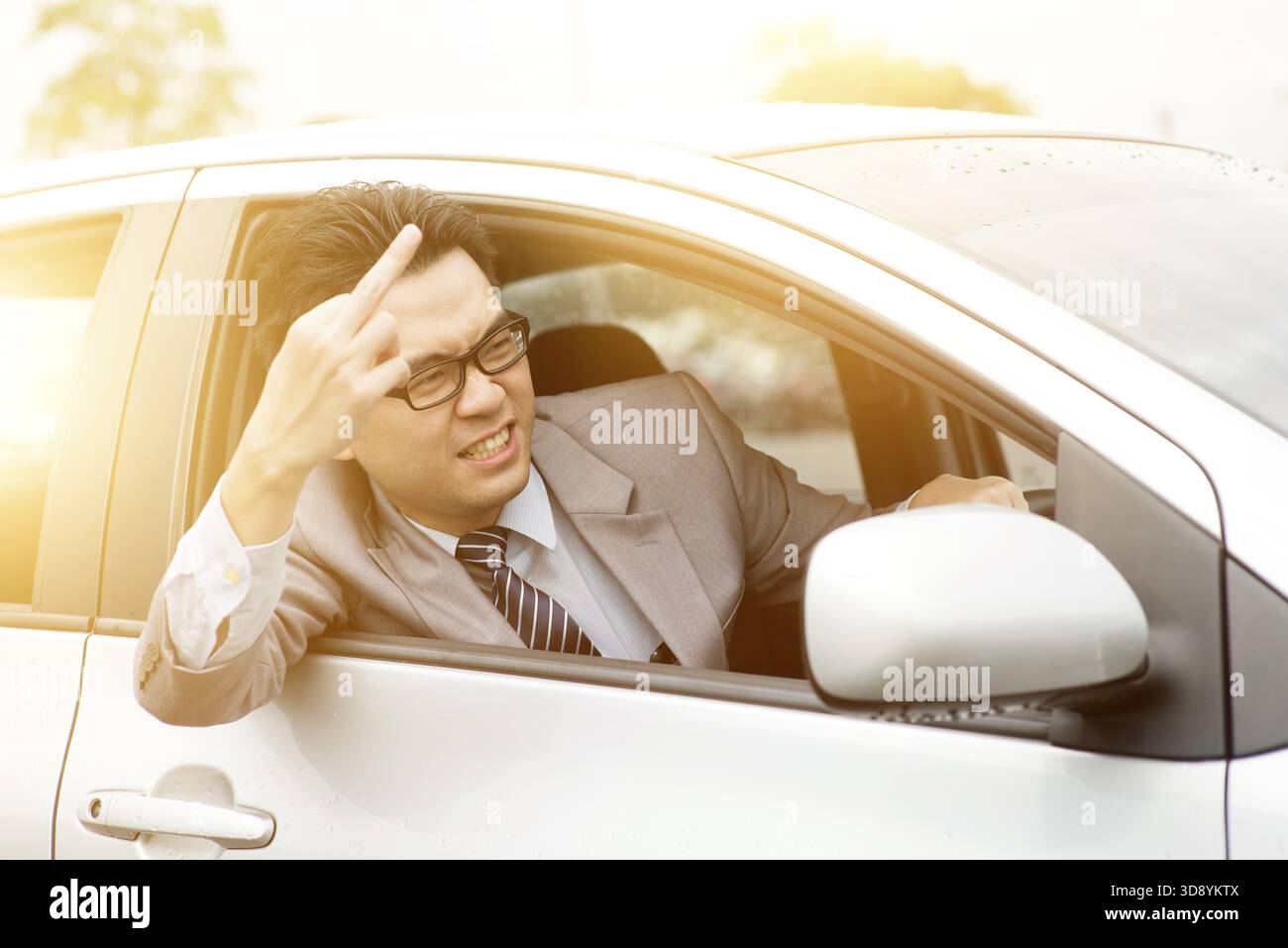 Wütender, unhöflicher Fahrer, der den Mittelfinger im Verkehr zeigt. Negative menschliche Expression Stockfoto