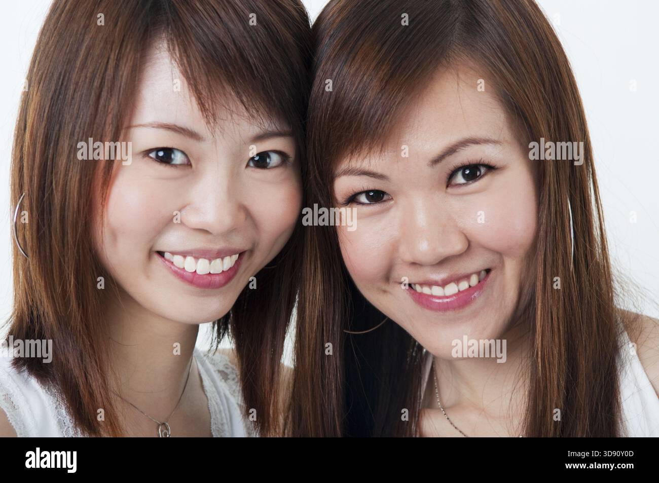 Schließen Sie sich fröhlich asiatische Mädchen auf weißem Hintergrund Stockfoto