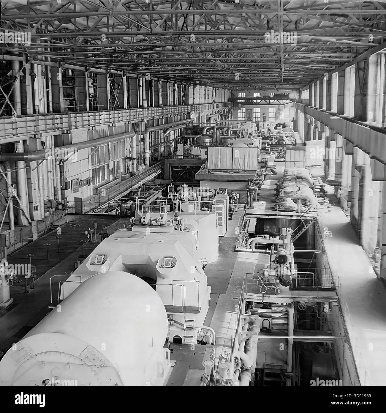 Historisches Schwarzweiß-Archivfoto aus dem Jahr 1976, das das Innere des Kramatorsker Blockheizkraftwerks (KWK) in der Region Donezk in der sowjetischen Ukraine erfasst. Eine Weitwinkelaufnahme zeigt eine lange Reihe von massiven Dampfturbinen und Generatoren in der Turbinenhalle. Das Bild zeigt die Größenordnung der Energieerzeugung, der schweren Maschinen und der industriellen Architektur der friedlichen Donbass-Ära vor dem modernen Krieg. Stockfoto