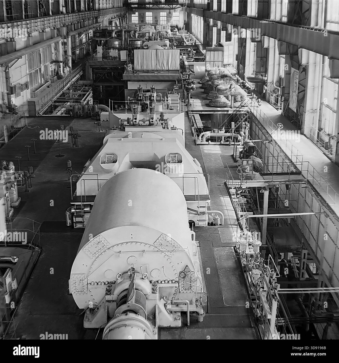 Historisches Schwarzweiß-Archivfoto aus dem Jahr 1976, das das Innere des Kramatorsker Blockheizkraftwerks (KWK) in der Region Donezk in der sowjetischen Ukraine erfasst. Eine Weitwinkelaufnahme zeigt eine lange Reihe von massiven Dampfturbinen und Generatoren in der Turbinenhalle. Das Bild zeigt die Größenordnung der Energieerzeugung, der schweren Maschinen und der industriellen Architektur der friedlichen Donbass-Ära vor dem modernen Krieg. Stockfoto