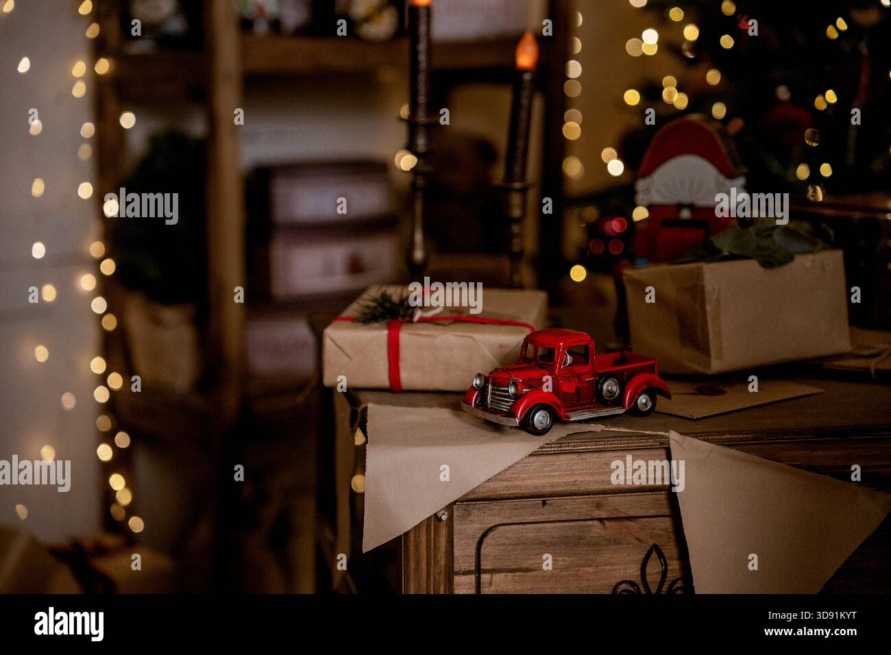 Festliche Neujahrsfeier mit rotem Auto, Geschenkverpackung, Geschenk-Lieferung an Kinder für die Feiertage Stockfoto