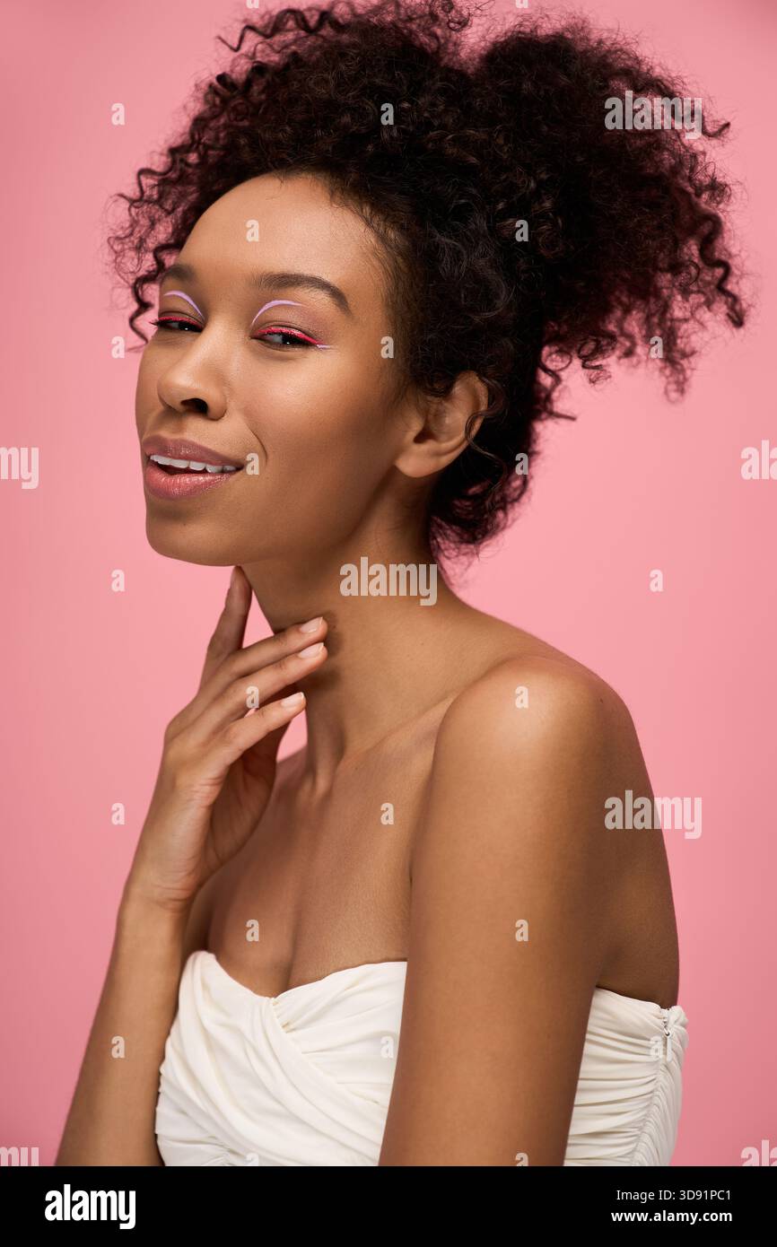 Eine junge, schöne Frau mit lockigem Haar bietet einen fesselnden Blick und zeigt ihre natürliche Schönheit. Stockfoto