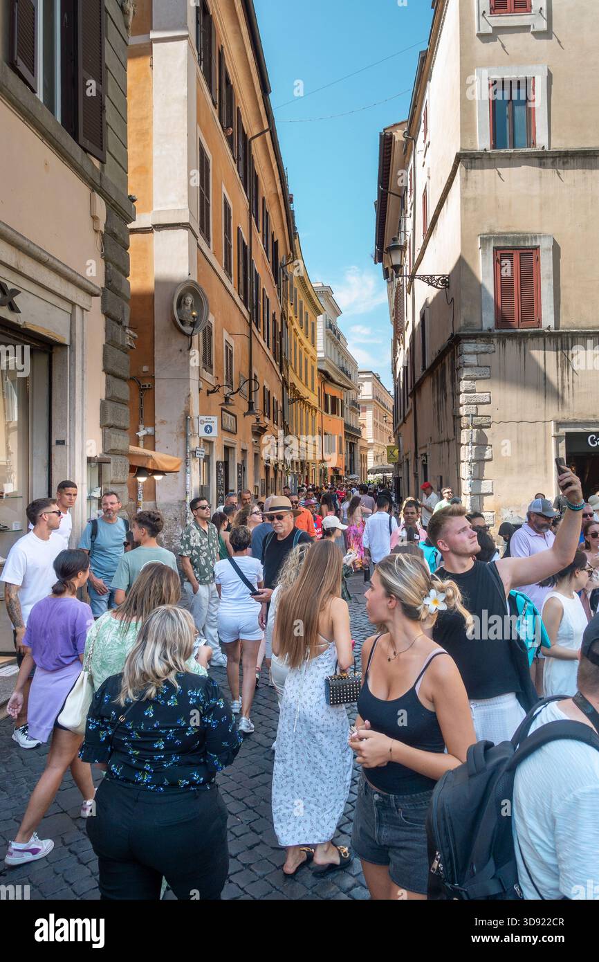 Touristen, die den Trevi-Brunnen besuchen. Der Trevi-Brunnen ist ein ikonisches Symbol des kaiserlichen Roms. Es ist eine der beliebtesten Touristenattraktionen Roms. Stockfoto