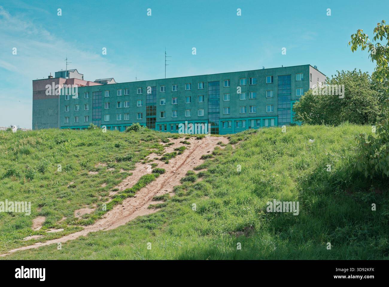 Apartment-Block aus der sozialistischen Ära hinter einer grasbewachsenen Wiese in Nowa Huta. Stockfoto