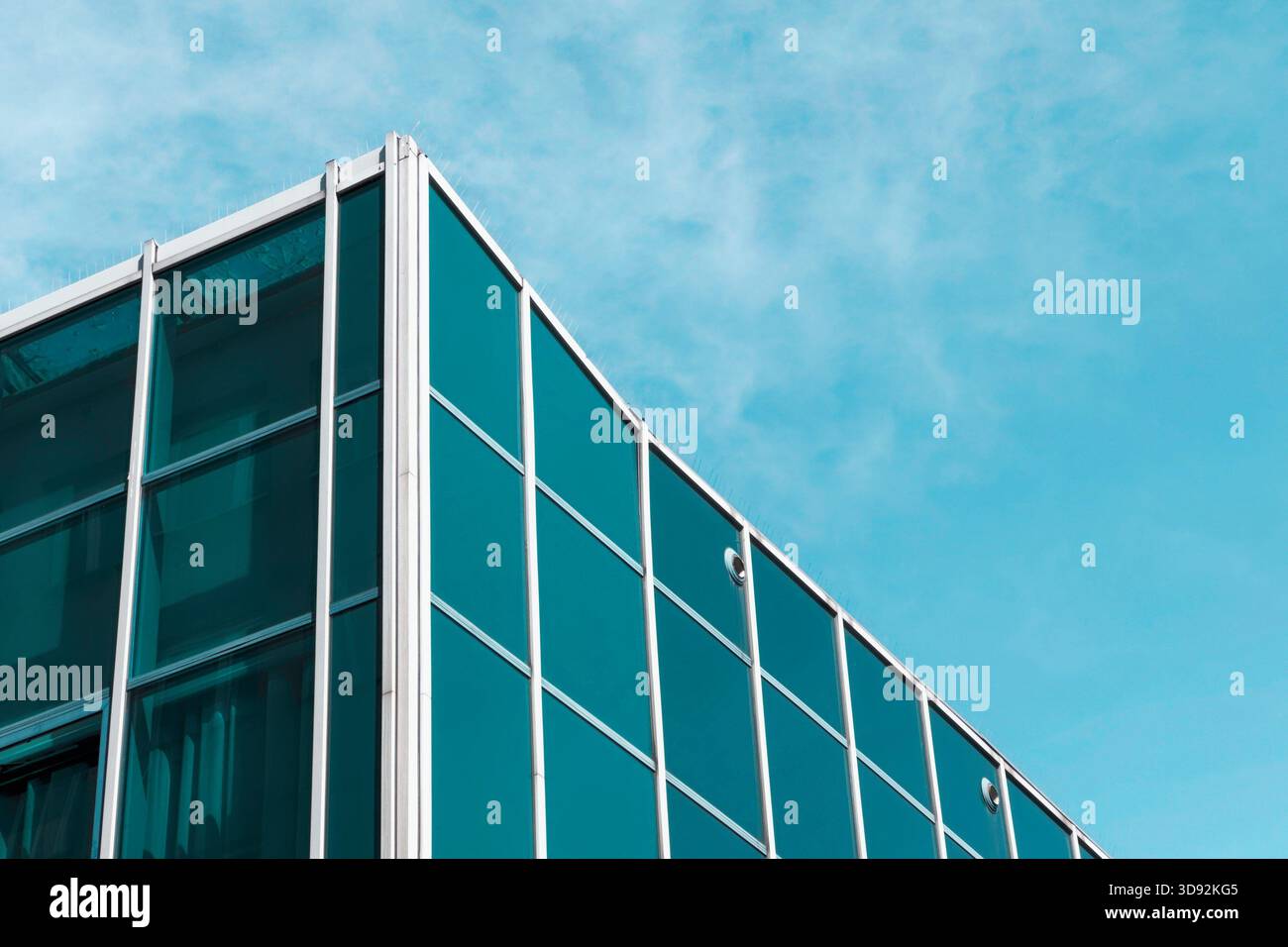 Modernistische Glasbauecke vor blauem Himmel. Stockfoto